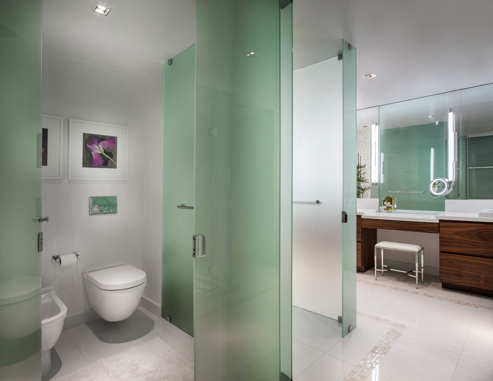 Design ideas for a contemporary ensuite bathroom in Miami with flat-panel cabinets, medium wood cabinets, a corner shower, a two-piece toilet, beige tiles, mosaic tiles, multi-coloured walls, a vessel sink and solid surface worktops.