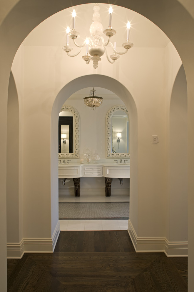 Cette image montre une salle de bain méditerranéenne avec des portes de placard blanches et un placard avec porte à panneau encastré.