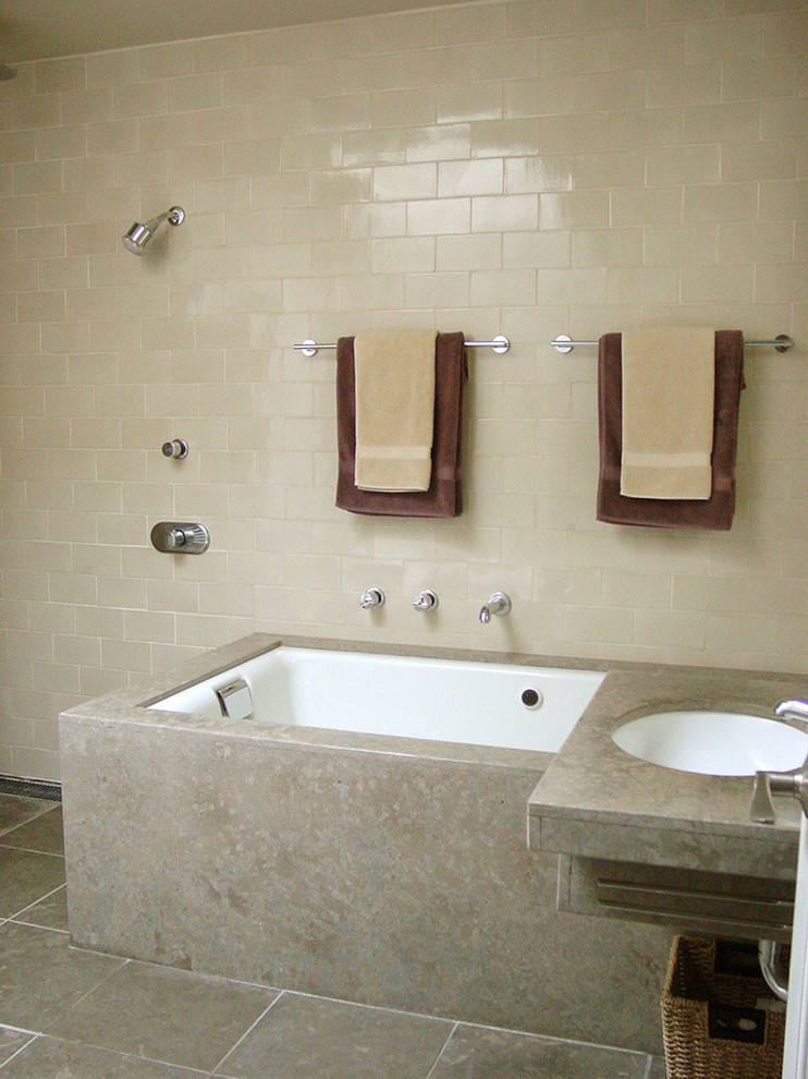Photo of a medium sized contemporary ensuite bathroom in San Francisco with a submerged sink, shaker cabinets, white cabinets, limestone worktops, a submerged bath, a built-in shower, a wall mounted toilet, beige tiles, ceramic tiles, beige walls, limestone flooring, beige floors and an open shower.