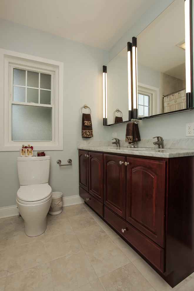 Inredning av ett klassiskt badrum, med ett undermonterad handfat, skåp i shakerstil, skåp i mörkt trä, en hörndusch, en toalettstol med separat cisternkåpa, beige kakel och porslinskakel