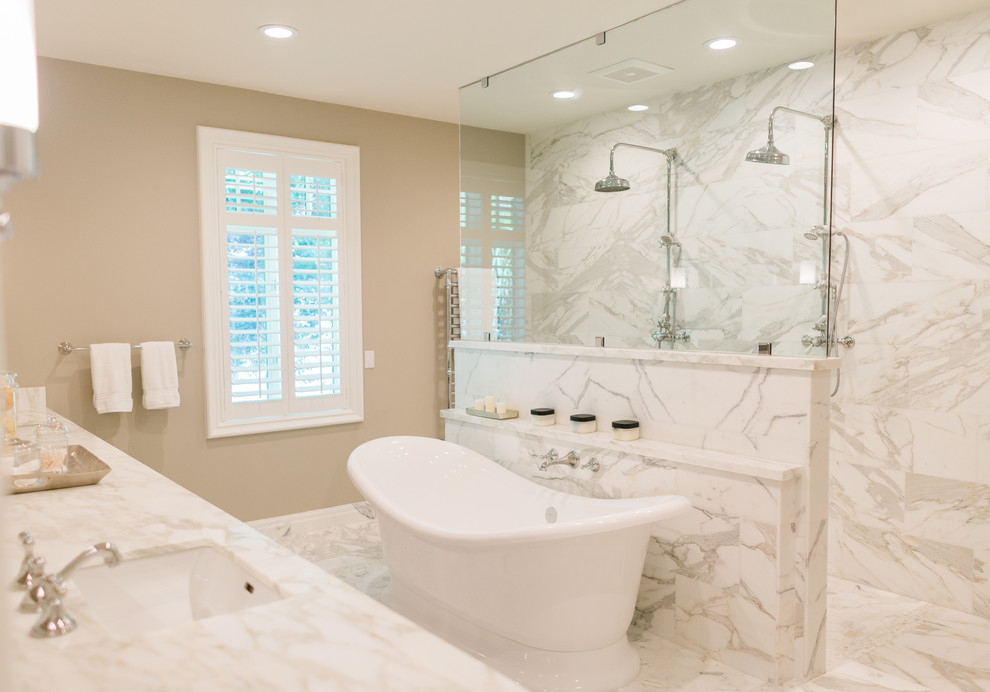 Foto på ett stort vintage en-suite badrum, med skåp i shakerstil, ett fristående badkar, en kantlös dusch, stenkakel, beige väggar, marmorgolv, ett undermonterad handfat och marmorbänkskiva