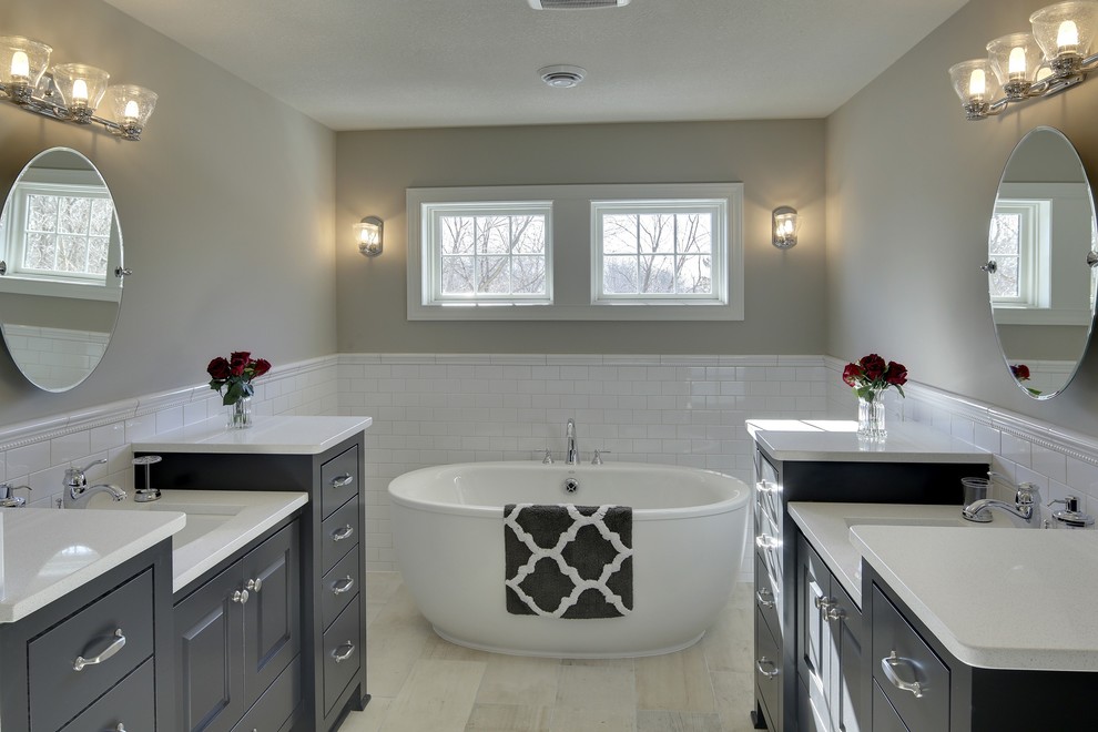 Exempel på ett stort klassiskt en-suite badrum, med luckor med infälld panel, svarta skåp, ett fristående badkar, beige kakel, keramikplattor, grå väggar och klinkergolv i porslin