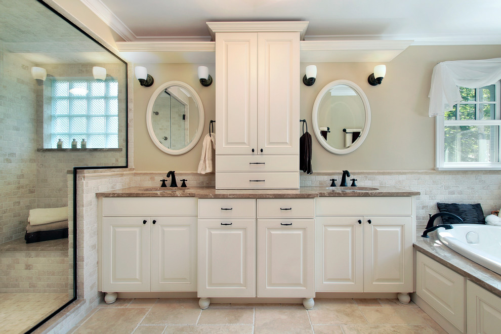 Modelo de cuarto de baño tradicional con armarios con paneles con relieve, puertas de armario blancas y bañera encastrada
