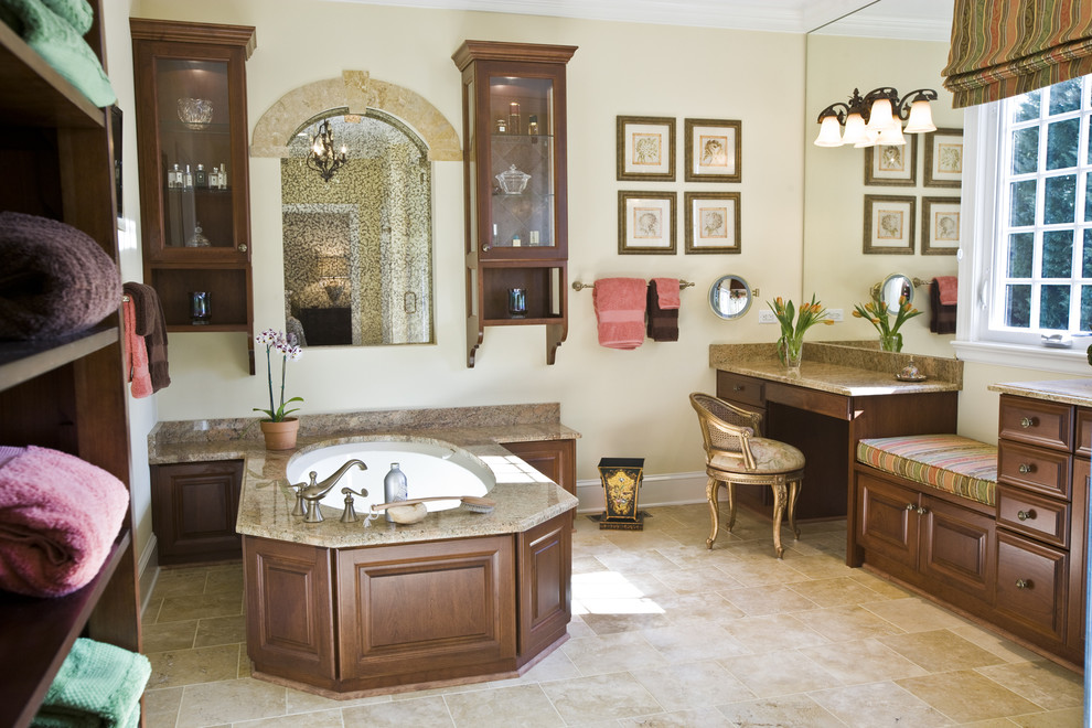 На фото: ванная комната в классическом стиле с темными деревянными фасадами, полновстраиваемой ванной, бежевой плиткой и фасадами с выступающей филенкой