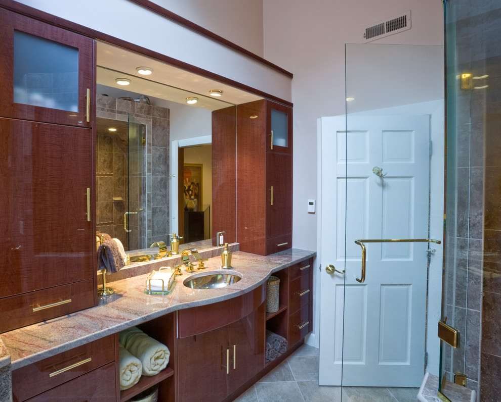 На фото: большая главная ванная комната в средиземноморском стиле с плоскими фасадами, темными деревянными фасадами, полновстраиваемой ванной, угловым душем, унитазом-моноблоком, бежевой плиткой, коричневой плиткой, разноцветной плиткой, керамической плиткой, бежевыми стенами, полом из керамической плитки, врезной раковиной и столешницей из гранита с
