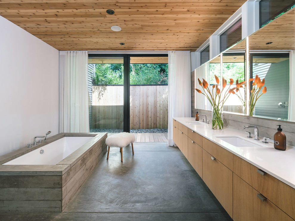 Modernes Badezimmer En Suite mit flächenbündigen Schrankfronten, hellen Holzschränken, Unterbauwanne, weißer Wandfarbe, Betonboden, Unterbauwaschbecken, grauem Boden und weißer Waschtischplatte in Portland
