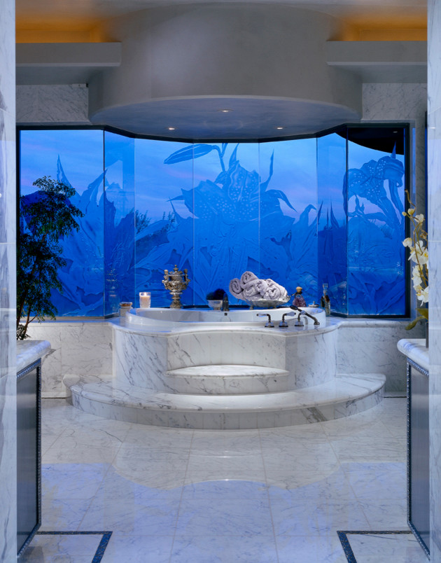 Ejemplo de cuarto de baño principal mediterráneo de tamaño medio con armarios con paneles empotrados, bañera esquinera, baldosas y/o azulejos de piedra, paredes beige y encimera de mármol