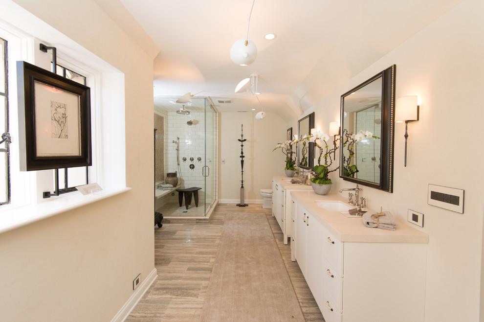 Exempel på ett stort klassiskt en-suite badrum, med luckor med infälld panel, vita skåp, ett fristående badkar, en hörndusch, en toalettstol med separat cisternkåpa, vit kakel, tunnelbanekakel, vita väggar, vinylgolv, ett undermonterad handfat, marmorbänkskiva, brunt golv och dusch med gångjärnsdörr