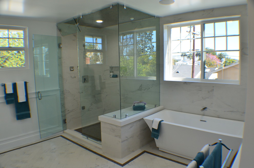 ロサンゼルスにある高級な中くらいなトランジショナルスタイルのおしゃれなマスターバスルーム (置き型浴槽、コーナー設置型シャワー、白い壁、大理石の床、マルチカラーの床、開き戸のシャワー、レイズドパネル扉のキャビネット、白いキャビネット、大理石の洗面台、白い洗面カウンター、一体型トイレ	、白いタイル、セラミックタイル、アンダーカウンター洗面器) の写真