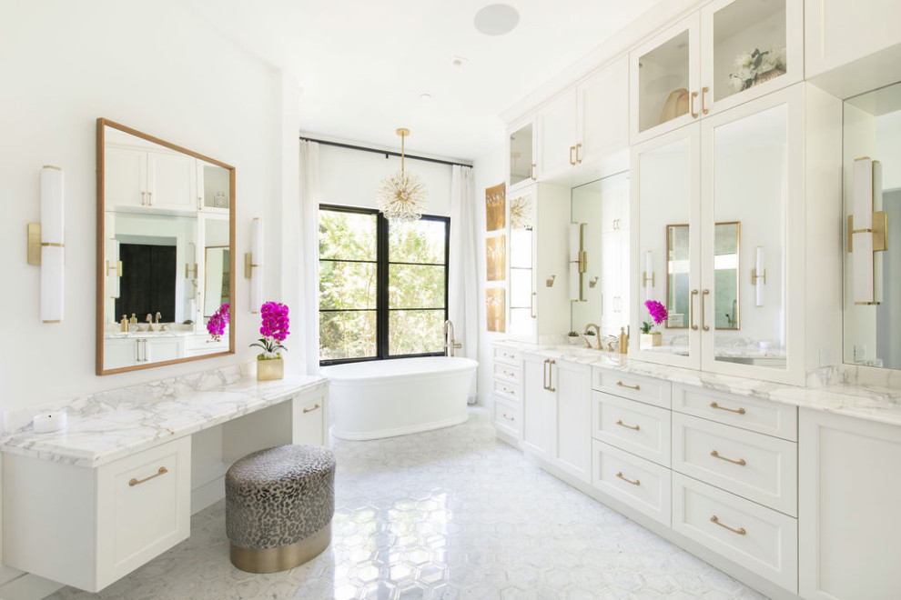 Inredning av ett klassiskt stort vit vitt en-suite badrum, med skåp i shakerstil, vita skåp, ett fristående badkar, en dusch i en alkov, en toalettstol med separat cisternkåpa, vit kakel, vita väggar, marmorgolv, ett undermonterad handfat, vitt golv och med dusch som är öppen
