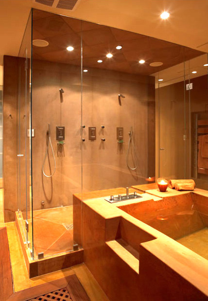 Modern inredning av ett stort en-suite badrum, med öppna hyllor, skåp i ljust trä, en jacuzzi, en kantlös dusch, spegel istället för kakel, bruna väggar, ett väggmonterat handfat och träbänkskiva