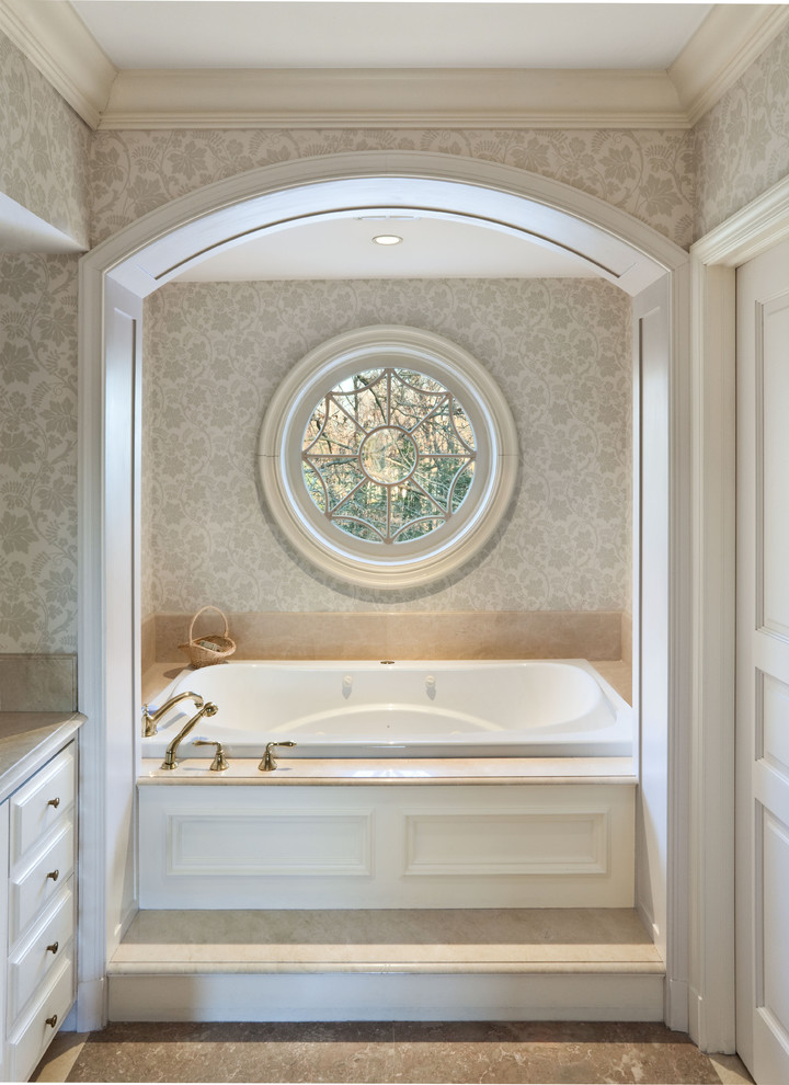 Imagen de cuarto de baño clásico con armarios con paneles con relieve, puertas de armario blancas, bañera encastrada y baldosas y/o azulejos beige
