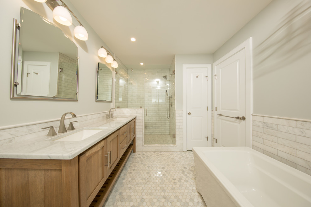 Mid-sized transitional master white tile and marble tile marble floor and white floor bathroom photo in DC Metro with recessed-panel cabinets, medium tone wood cabinets, a two-piece toilet, white walls, an undermount sink, marble countertops and a hinged shower door