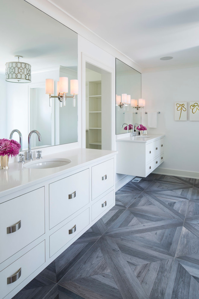 Klassisches Badezimmer En Suite mit flächenbündigen Schrankfronten, weißen Schränken, weißer Wandfarbe, dunklem Holzboden, Waschtischkonsole und grauem Boden in Minneapolis