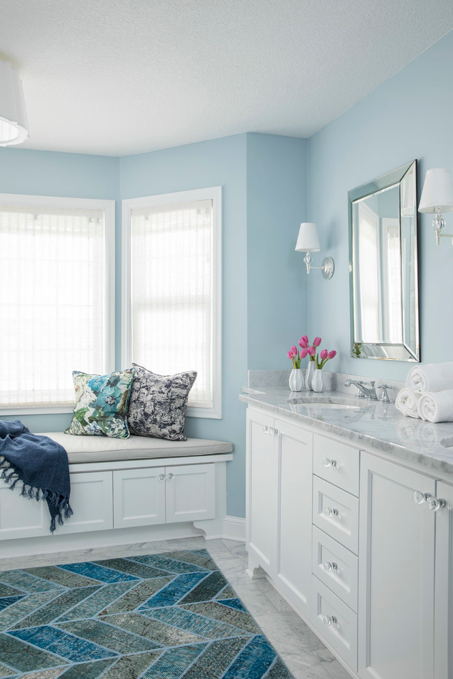 Пример оригинального дизайна: большая главная ванная комната в классическом стиле с белыми фасадами, синими стенами, врезной раковиной, фасадами в стиле шейкер, душем без бортиков, раздельным унитазом, белой плиткой, мраморной плиткой, мраморным полом, мраморной столешницей, белым полом, душем с распашными дверями, серой столешницей и зеркалом с подсветкой