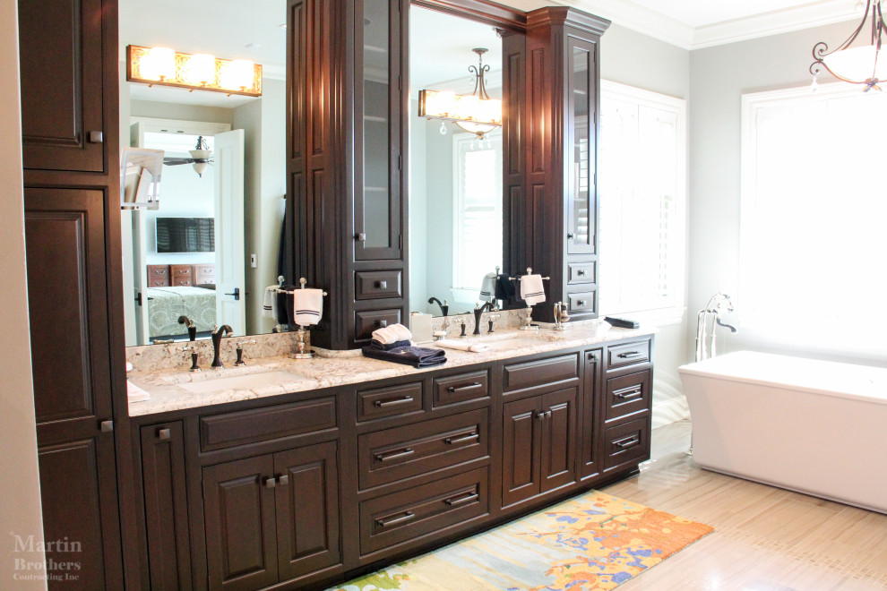 Example of a large classic master marble floor, beige floor and double-sink bathroom design in Other with raised-panel cabinets, dark wood cabinets, a one-piece toilet, gray walls, an undermount sink, granite countertops, a hinged shower door and a built-in vanity