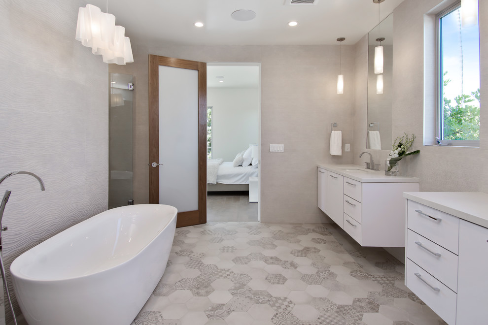 Пример оригинального дизайна: большая главная ванная комната в стиле ретро с плоскими фасадами, белыми фасадами, отдельно стоящей ванной, унитазом-моноблоком, серыми стенами, полом из керамической плитки, столешницей из искусственного камня, керамической плиткой, душем без бортиков, серой плиткой, врезной раковиной, разноцветным полом, душем с распашными дверями и белой столешницей