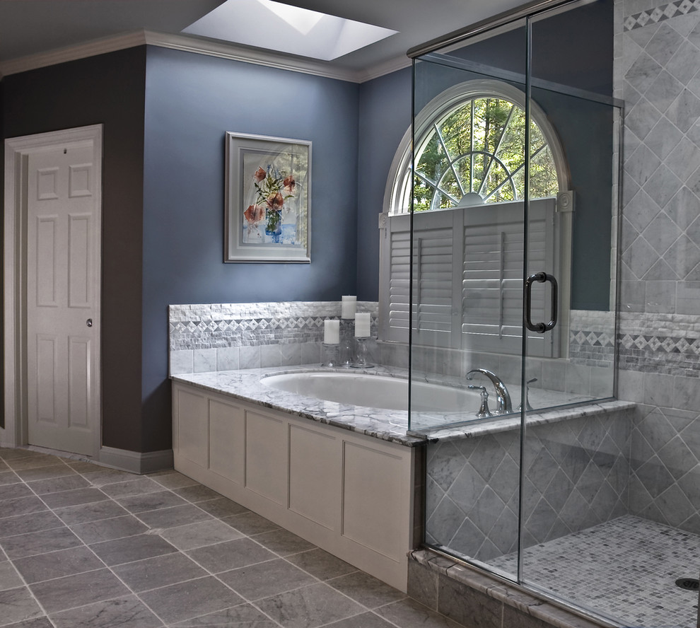 Elegant gray tile corner shower photo in Boston with recessed-panel cabinets and an undermount tub