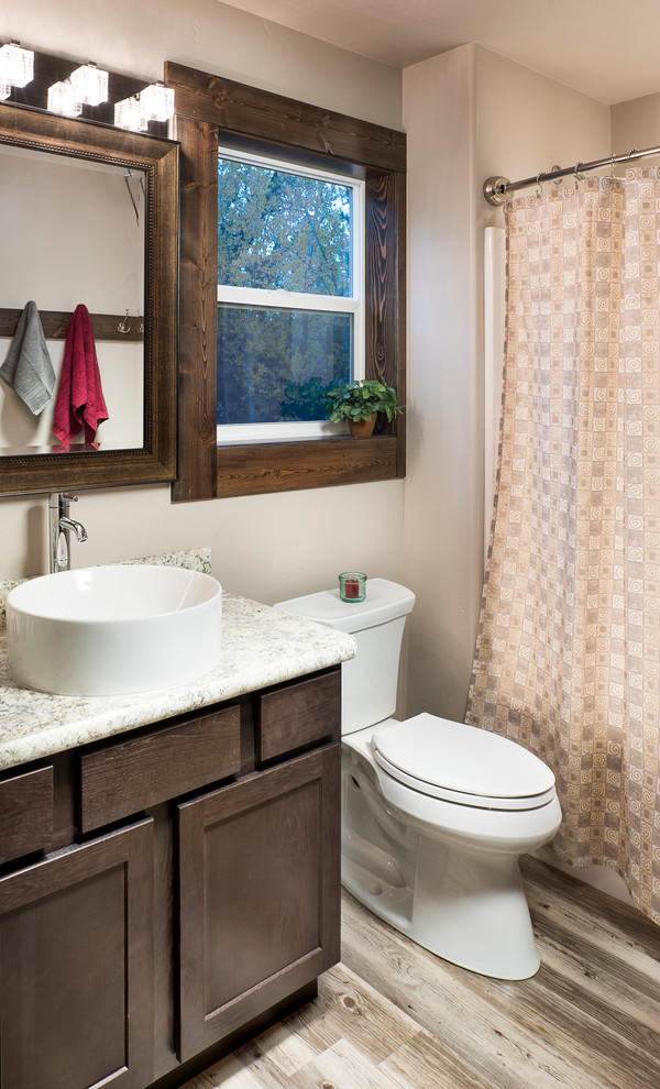 Exemple d'une petite salle de bain principale chic en bois foncé avec un placard à porte shaker, WC séparés, un mur gris, un sol en vinyl, une vasque et un plan de toilette en stratifié.