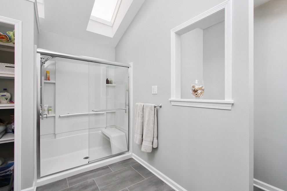 Diseño de cuarto de baño principal actual de tamaño medio con ducha empotrada, baldosas y/o azulejos grises, baldosas y/o azulejos de porcelana, paredes grises, suelo vinílico y armarios estilo shaker