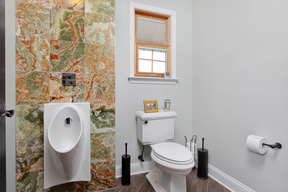 Идея дизайна: большой туалет в стиле неоклассика (современная классика) с писсуаром, каменной плиткой, серыми стенами, полом из керамической плитки и врезной раковиной