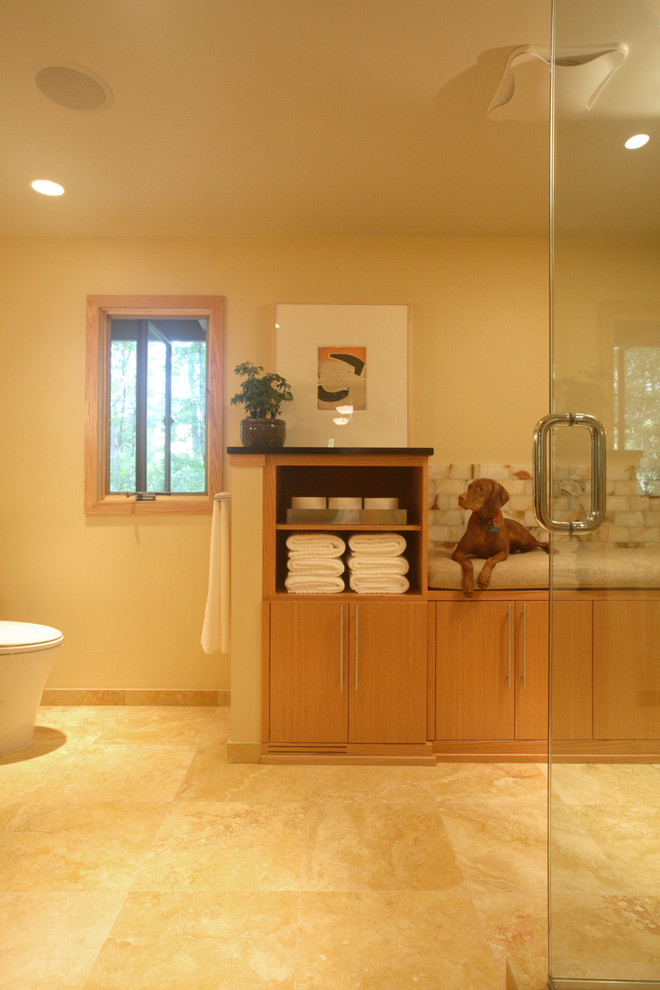 На фото: большая главная ванная комната в стиле неоклассика (современная классика) с плоскими фасадами, светлыми деревянными фасадами, столешницей из гранита, угловым душем и полом из известняка