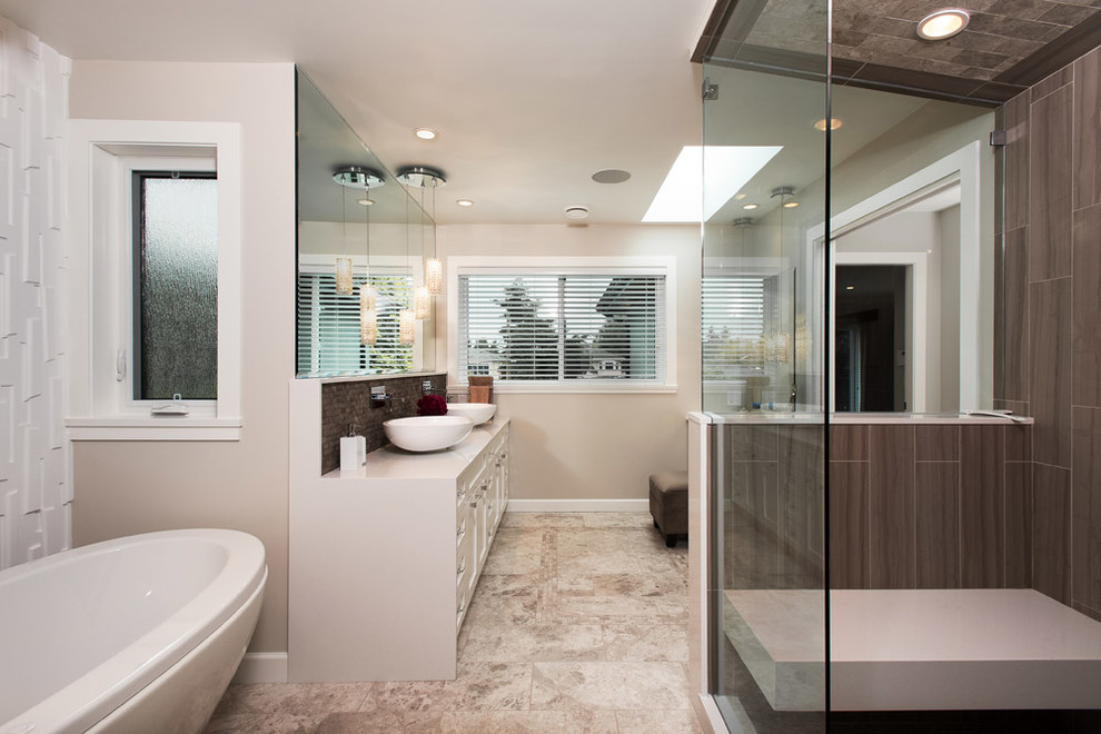 Inredning av ett modernt stort badrum, med ett fristående badkar, brun kakel, ett fristående handfat, vita skåp, bänkskiva i kvarts, en dusch i en alkov och stenkakel