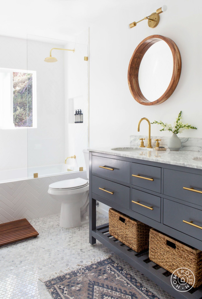 Пример оригинального дизайна: маленькая главная ванная комната в морском стиле с фасадами островного типа, синими фасадами, накладной ванной, душем над ванной, унитазом-моноблоком, белой плиткой, плиткой кабанчик, белыми стенами, полом из мозаичной плитки, врезной раковиной, мраморной столешницей, белым полом, открытым душем и белой столешницей для на участке и в саду