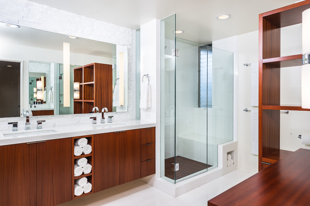 Corner shower - large 1960s master white tile and stone tile marble floor corner shower idea in Los Angeles with flat-panel cabinets, medium tone wood cabinets, a one-piece toilet, white walls, an undermount sink and quartz countertops