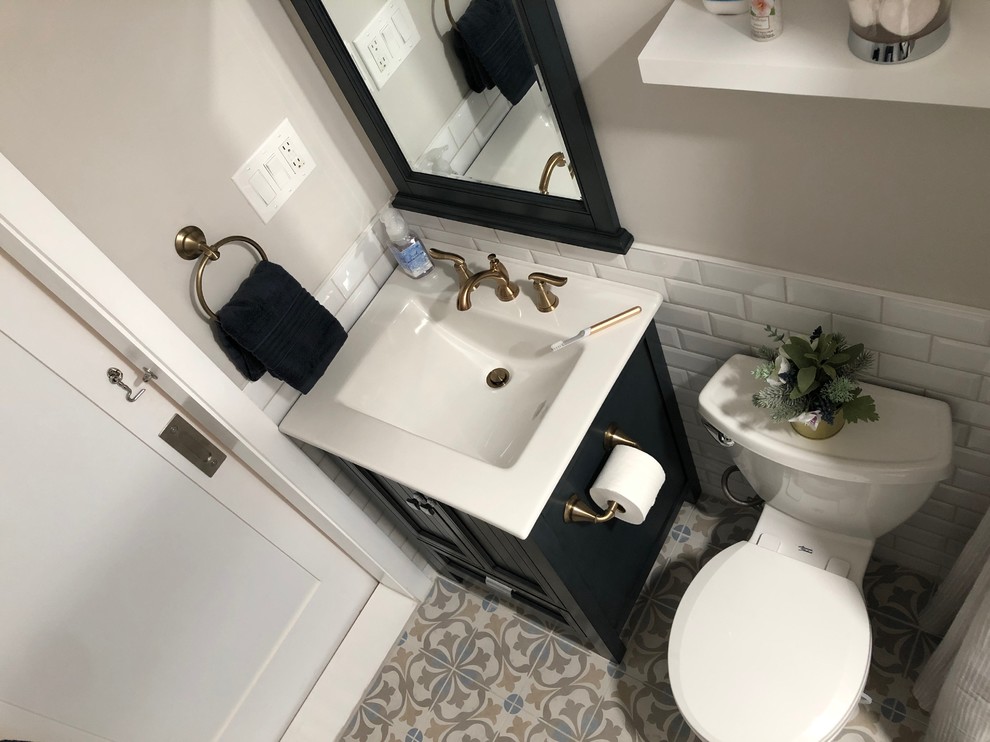 Inspiration for a small transitional master white tile and ceramic tile ceramic tile and beige floor bathroom remodel in Philadelphia with furniture-like cabinets, blue cabinets, a two-piece toilet, beige walls, an integrated sink, solid surface countertops and white countertops