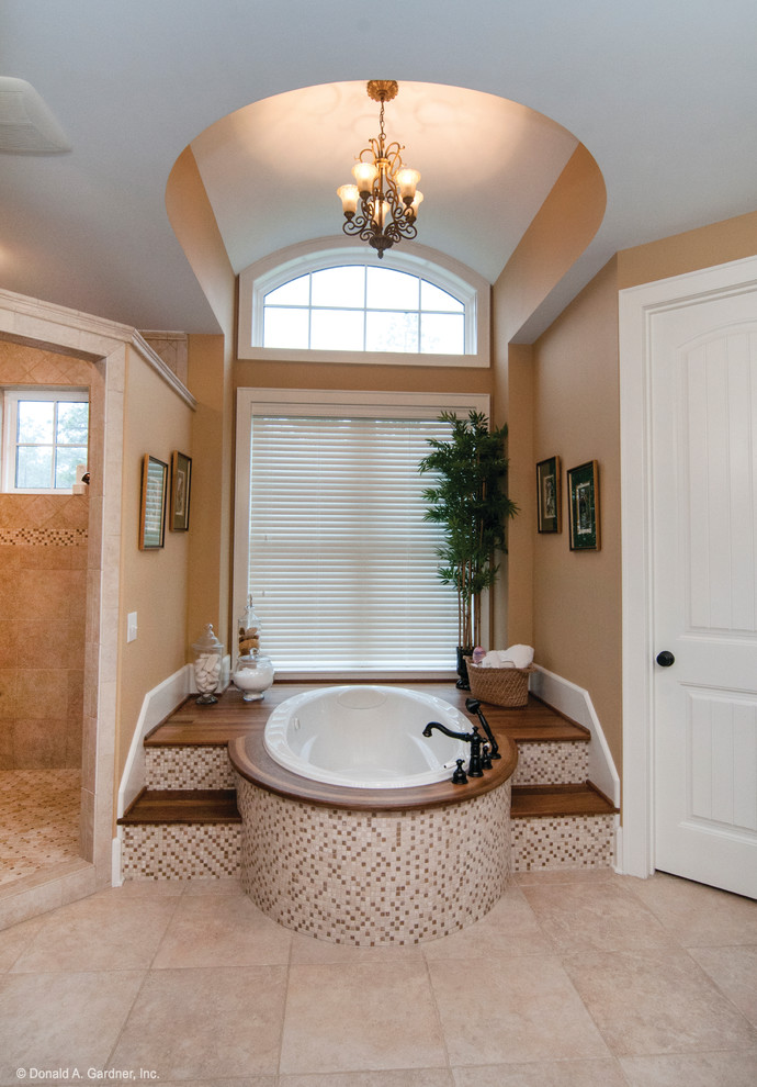 Foto di una grande stanza da bagno padronale american style con lavabo sottopiano, ante in legno bruno, top in granito, vasca ad alcova, doccia ad angolo, piastrelle beige e pareti beige