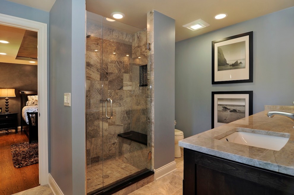 Mid-sized transitional master multicolored tile and stone tile travertine floor doorless shower photo in Chicago with recessed-panel cabinets, dark wood cabinets, a one-piece toilet, blue walls, an undermount sink and granite countertops