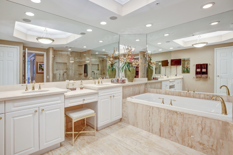 マイアミにあるトラディショナルスタイルのおしゃれなマスターバスルーム (レイズドパネル扉のキャビネット、白いキャビネット、アルコーブ型浴槽、アンダーカウンター洗面器) の写真