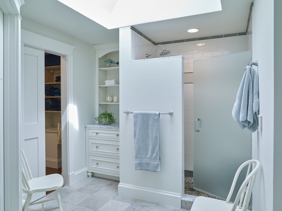 Photo of a coastal bathroom in Portland Maine with an alcove shower, white tiles, metro tiles, grey walls, grey floors and a hinged door.