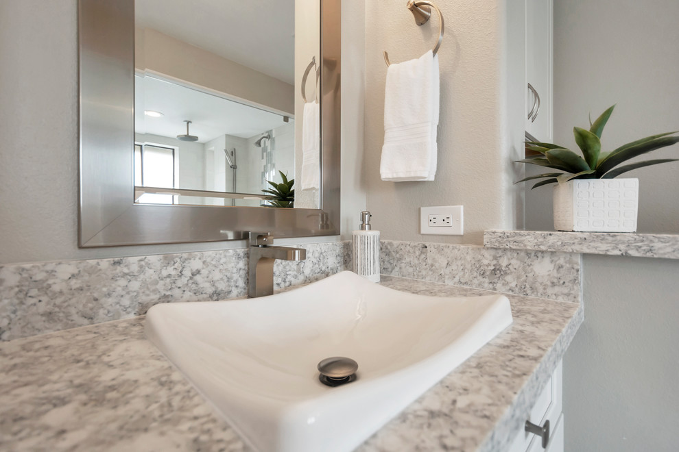 Bathroom - large transitional master gray tile and porcelain tile porcelain tile and brown floor bathroom idea in Phoenix with shaker cabinets, white cabinets, gray walls, a drop-in sink, quartz countertops and gray countertops