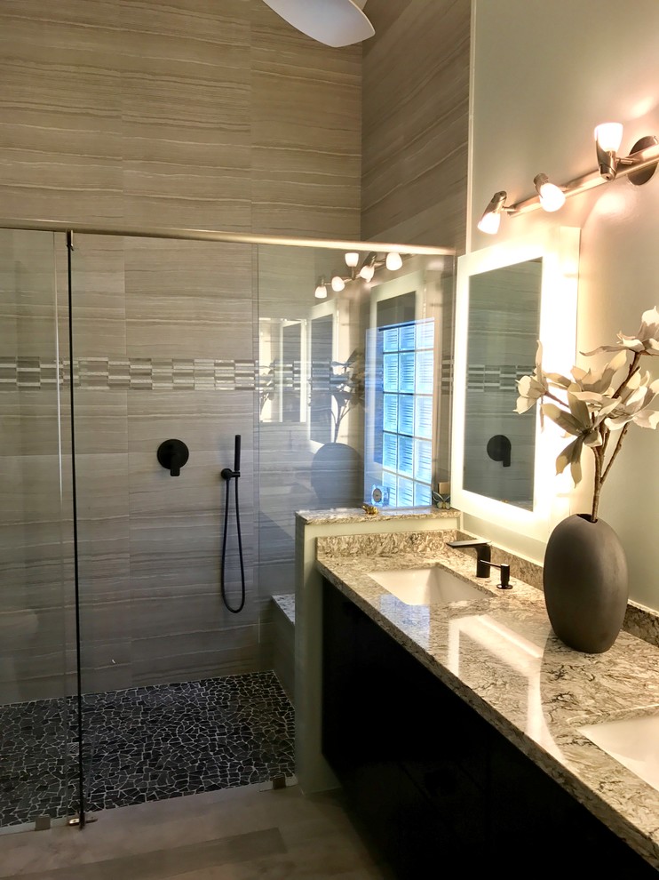 Example of a mid-sized trendy master gray tile and ceramic tile porcelain tile and gray floor walk-in shower design in Miami with flat-panel cabinets, dark wood cabinets, a two-piece toilet, beige walls, an undermount sink, solid surface countertops, a hinged shower door and multicolored countertops