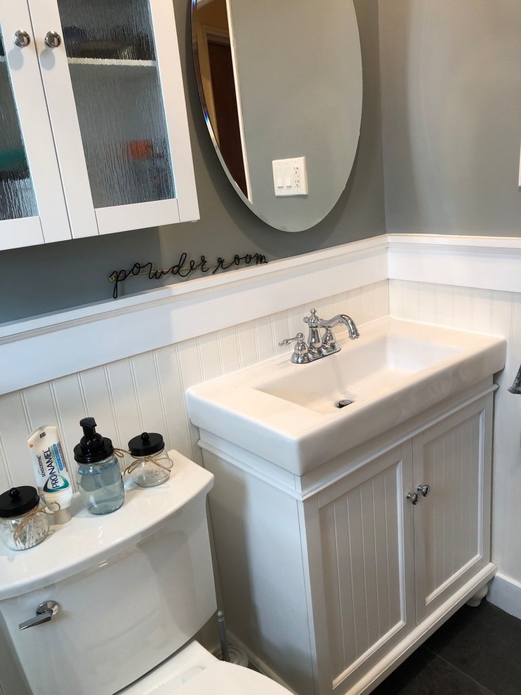 Bathroom - mid-sized transitional master white tile and ceramic tile porcelain tile and gray floor bathroom idea in New York with furniture-like cabinets, white cabinets, a two-piece toilet, gray walls, an integrated sink, solid surface countertops and white countertops