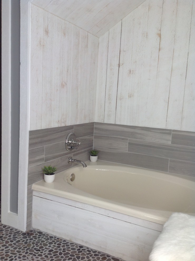 Exemple d'une salle de bain principale bord de mer en bois foncé de taille moyenne avec un placard en trompe-l'oeil, une baignoire en alcôve, un carrelage beige, un carrelage marron, un carrelage multicolore, un carrelage blanc, une plaque de galets, un mur gris, un sol en galet, un lavabo posé et un plan de toilette en marbre.