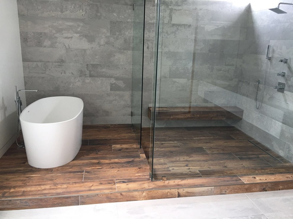 На фото: главная ванная комната среднего размера в стиле модернизм с плоскими фасадами, белыми фасадами, отдельно стоящей ванной, угловым душем, унитазом-моноблоком, серой плиткой, цементной плиткой, белыми стенами, полом из керамической плитки, монолитной раковиной, столешницей из искусственного кварца, разноцветным полом, душем с распашными дверями и разноцветной столешницей с