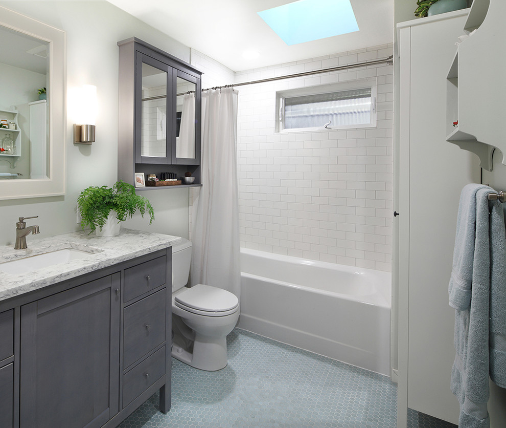 Inredning av ett modernt mellanstort vit vitt en-suite badrum, med möbel-liknande, grå skåp, ett badkar i en alkov, en dusch/badkar-kombination, en toalettstol med separat cisternkåpa, blå kakel, porslinskakel, blå väggar, klinkergolv i porslin, ett nedsänkt handfat, bänkskiva i kvartsit, blått golv och dusch med duschdraperi