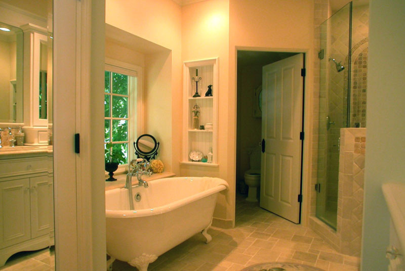 Свежая идея для дизайна: главная ванная комната среднего размера в классическом стиле с белыми фасадами, ванной на ножках, угловым душем, раздельным унитазом, бежевой плиткой, каменной плиткой, желтыми стенами и полом из травертина - отличное фото интерьера