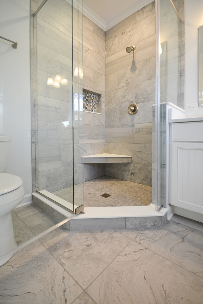Inredning av ett klassiskt mellanstort badrum med dusch, med luckor med infälld panel, vita skåp, en hörndusch, en toalettstol med separat cisternkåpa, grå kakel, marmorkakel, vita väggar, marmorgolv, ett undermonterad handfat, marmorbänkskiva, grått golv och dusch med gångjärnsdörr