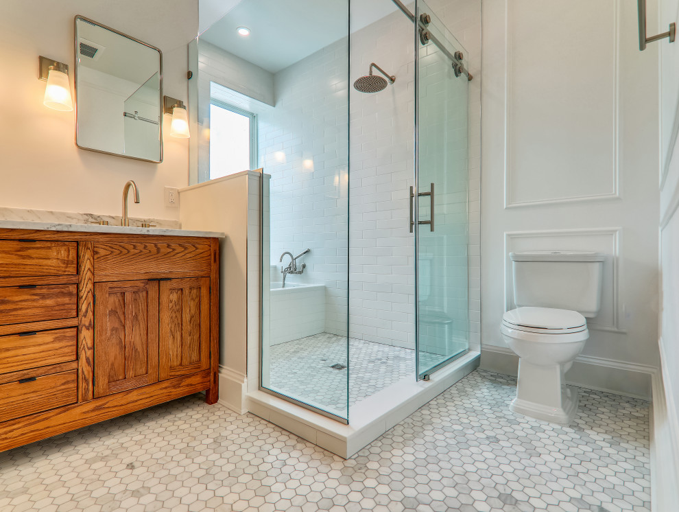 Medium sized contemporary ensuite bathroom in DC Metro with light wood cabinets, a built-in bath, a two-piece toilet, white tiles, ceramic tiles, white walls, ceramic flooring, a submerged sink, marble worktops, white floors, a sliding door, white worktops, a wall niche, double sinks, a freestanding vanity unit and panelled walls.