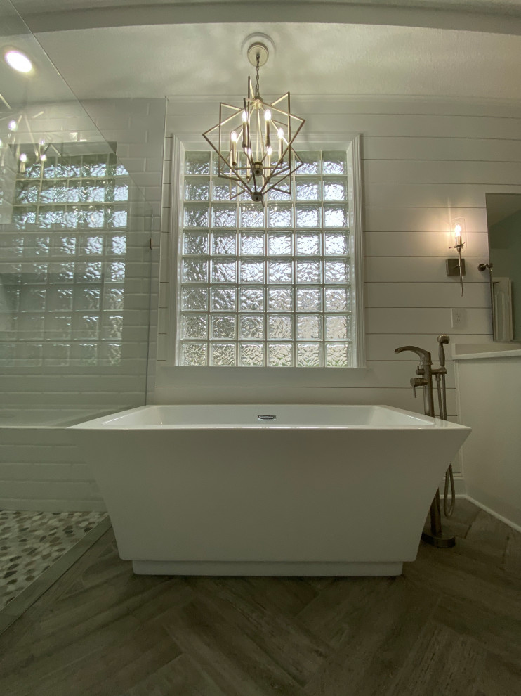 Inspiration for a large timeless master white tile and subway tile wood-look tile floor, gray floor, double-sink, tray ceiling and shiplap wall bathroom remodel in Jacksonville with shaker cabinets, white cabinets, a one-piece toilet, gray walls, a vessel sink, granite countertops, a hinged shower door, white countertops, a niche and a freestanding vanity