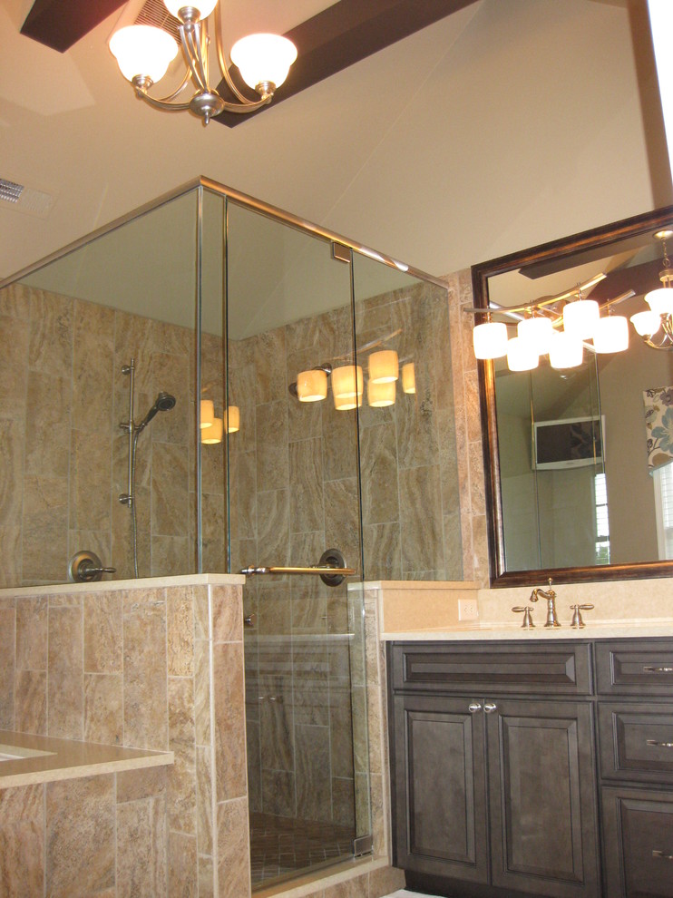 Inspiration for a large timeless master beige tile and porcelain tile porcelain tile and beige floor corner shower remodel in Charlotte with raised-panel cabinets, dark wood cabinets, an undermount tub, beige walls, an undermount sink, solid surface countertops and a hinged shower door