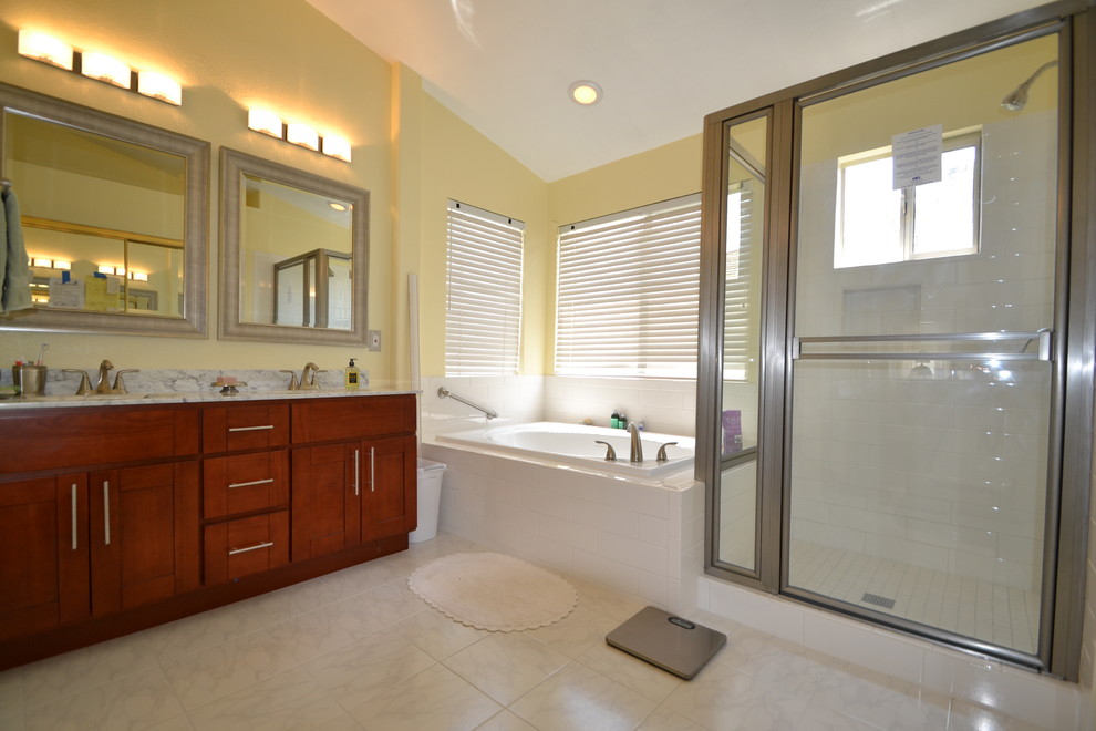 Large traditional ensuite bathroom in San Francisco with a built-in sink, shaker cabinets, brown cabinets, marble worktops, a corner shower, a one-piece toilet, white tiles, ceramic tiles, yellow walls and ceramic flooring.