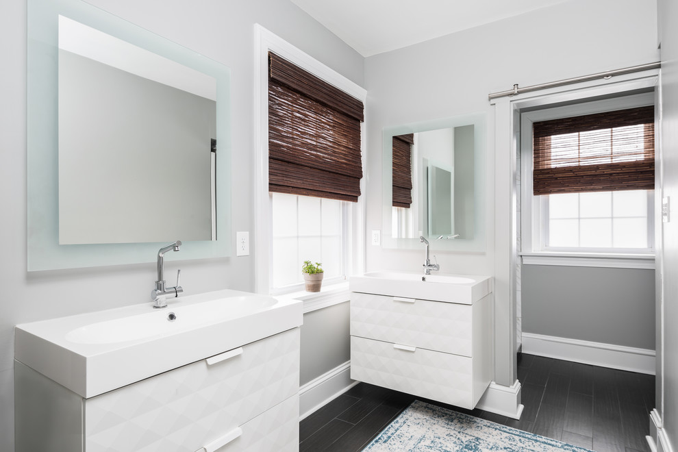 Cette image montre une salle de bain principale design avec des portes de placard blanches et un mur gris.
