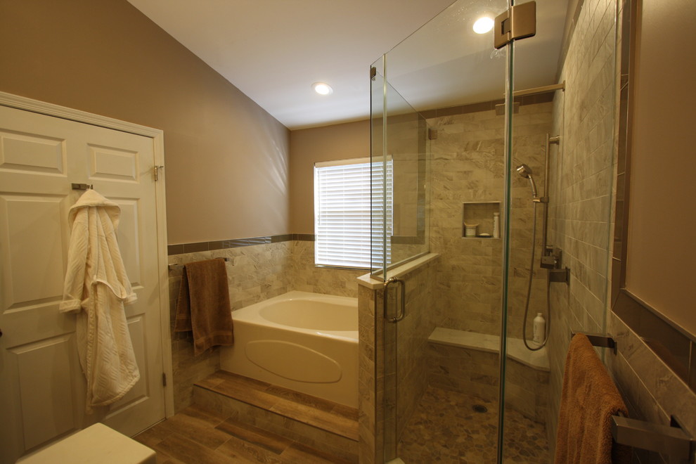 Cette photo montre une grande salle de bain principale tendance avec un placard à porte shaker, des portes de placard marrons, une baignoire en alcôve, une douche d'angle, WC à poser, un carrelage beige, un carrelage de pierre, un mur beige, une vasque, un plan de toilette en quartz modifié, une cabine de douche à porte battante et un sol en bois brun.