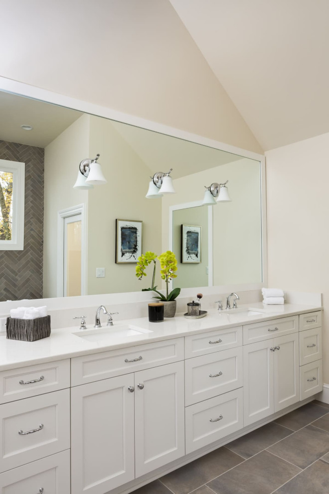 Photo of a large classic ensuite bathroom in Charlotte with shaker cabinets, white cabinets, a freestanding bath, a built-in shower, a two-piece toilet, beige tiles, porcelain tiles, beige walls, porcelain flooring, a submerged sink, engineered stone worktops, grey floors, a sliding door, white worktops, an enclosed toilet, double sinks, a built in vanity unit and a vaulted ceiling.