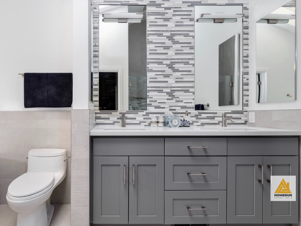 Mid-sized minimalist master gray tile and porcelain tile porcelain tile, gray floor and double-sink bathroom photo in San Francisco with gray cabinets, a one-piece toilet, white walls, an undermount sink, quartz countertops, a hinged shower door, white countertops, a niche and a freestanding vanity